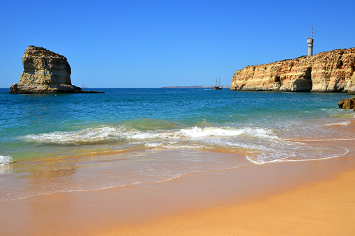 Ferragudo, Lagoa, Algarve / Faro District, Portugal: Caneiros Beach - in the background the Altar Headland with its coastal radar tower and the Gaivotas Islet - Praia dos Caneiros, Ponta do Altar e Leixão das Gaivotas