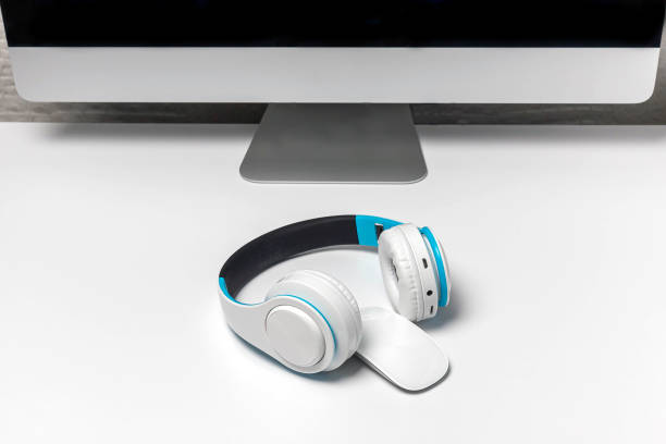 Earphones and computer monitor at workplace. Working with sound or listening to music at work. Listening to business phone conversations