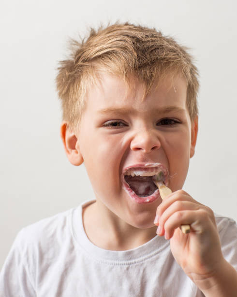 istock cute boy posing with bamboo toothbrush in his mouth, child brushes his teeth 1296195536