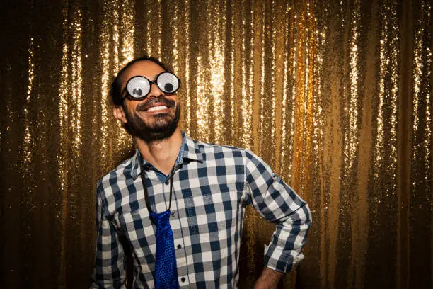 Smiling man wearing comedy glasses while enjoying party.