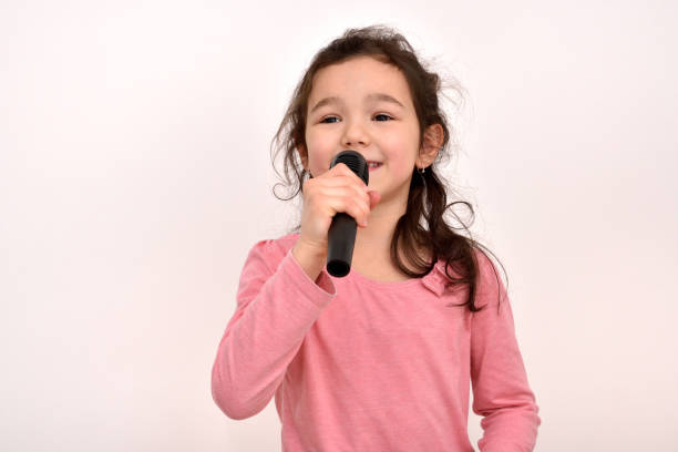 istock Young girl with a microphone singing 1296198540