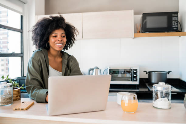istock Latin woman using laptop at home. 1296201646