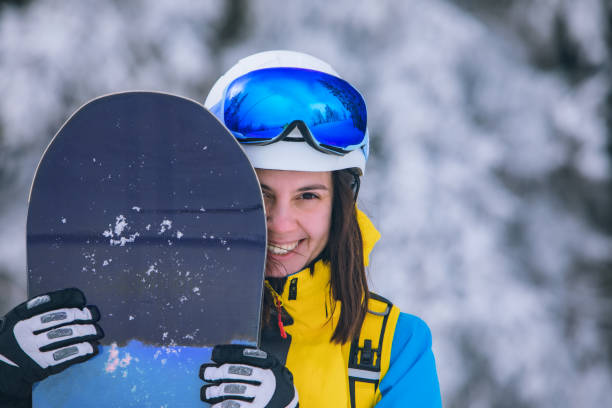 istock pretty woman snowboarder portrait 1296202376