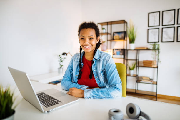 istock African-American Gen-Z woman looking at camera while working from home 1296203557