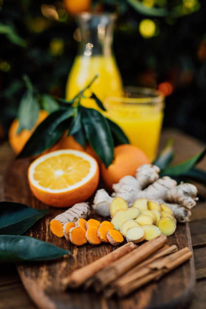 istock Vertical photo of sliced turmeric and ginger root with cinnamon and freshly squeezed orange juice of untreated Bio oranges from the own garden 1296204854