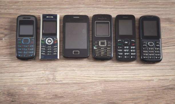 istock Old cell phones on wooden background. 1296204888