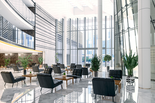 Luxury Hotel Lobby Or Company Lobby With Black Colored Leather Armchairs, Potted Plants, Coffee Tables And Tiled Floor.
