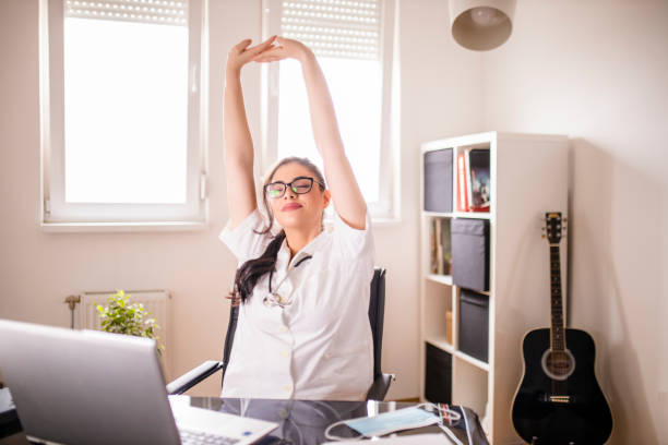 istock Female doctor using laptop and stretching at her office 1296206165