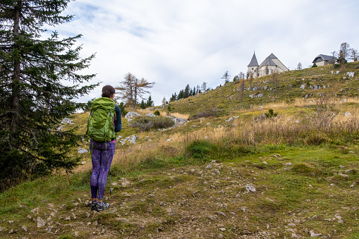 Woman hiker walking on the path to Urslja gora or Plesivec in the Koroska region of Slovenia