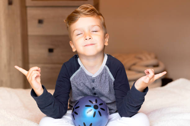 istock Cute kid meditating with eyes closed at home. 1296211821