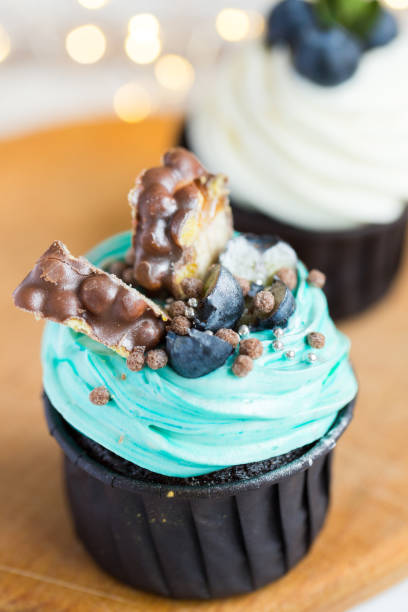 istock Cupcakes or muffins with chocolate cream and sweets. Cake celebration, delicious dessert, close-up 1296212580
