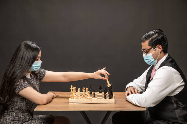 istock Elegant Couple playing chess. 1296214334