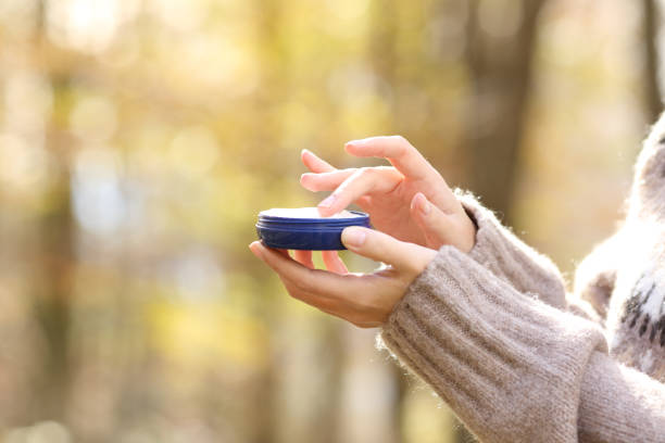 istock Woman hands holding moisturizer cream bottle in winter 1296216585