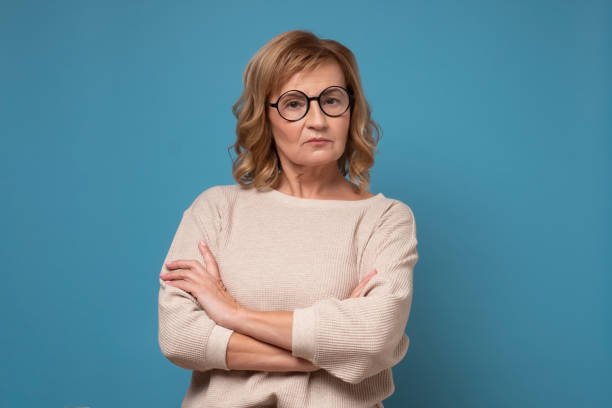 istock Serious elderly caucasian woman in glasses with folded hands. 1296216610