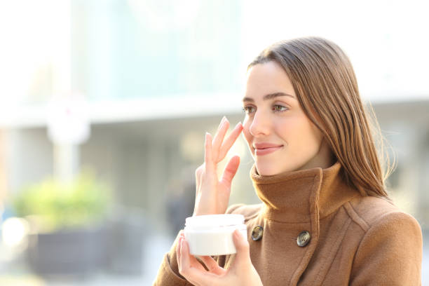 冬の顔にムスツーライザークリームを適用する女性 - human face rubbing women beauty treatment ストックフォトと画像