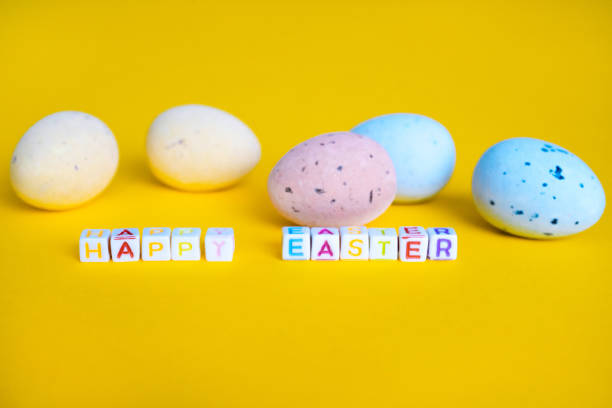 istock Easter greeting card with painted eggs. Seasonal Easter message Happy easter. Pastel and colorful decorated easter eggs with greeting card with text on yellow background. Spring holidays concept 1296217551