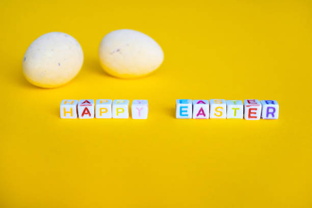 istock Easter greeting card with painted eggs. Seasonal Easter message Happy easter. Pastel and colorful decorated easter eggs with greeting card with text on yellow background. Spring holidays concept 1296217598