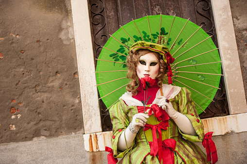 Venice, Italy - February 12, 2023: Beautiful portrait of a masked woman in costume inspired by Maleficent character during the Carnival of Venice, Italy