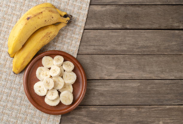 istock Bananas and slices over wooden table with copy space 1296218859