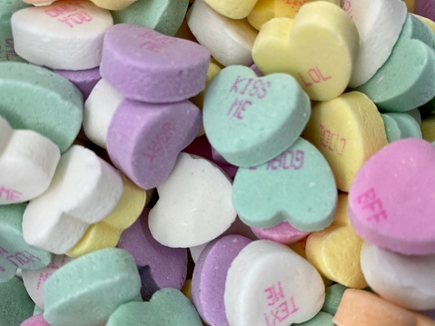 Looking down into a bowl of candy conversation hearts for Valentine's Day.