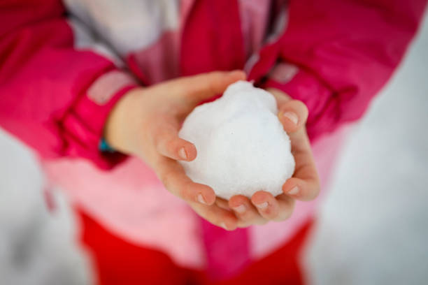 istock little girl hand with snowball 1296224632