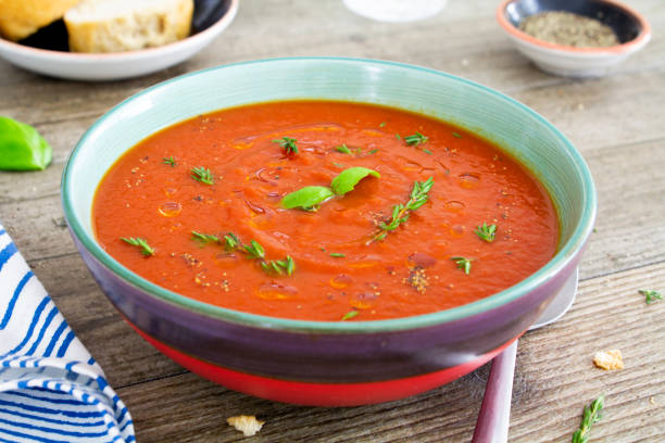 tomaten-basilikum-suppe auf einem rustikalen tisch - tomato soup red basil table stock-fotos und bilder