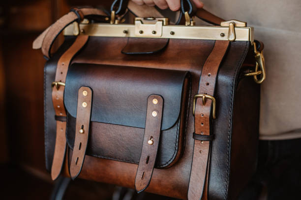 istock Business man holding elegant brown leather briefcase. 1296235367