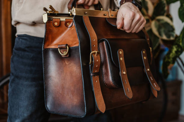 istock Business man holding elegant brown leather briefcase. 1296235379