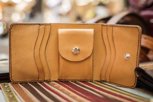 istock One closed light brown leather men's wallet on a wooden table. View from above. 1296235424
