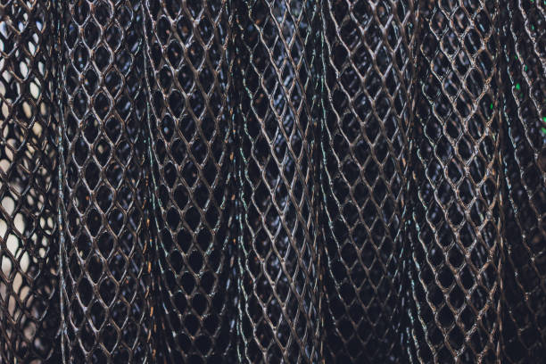 Black plastic polymer granules rolled into a tube close-up