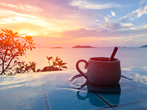 Vintage cup of hot coffee  beside the pool in morning view