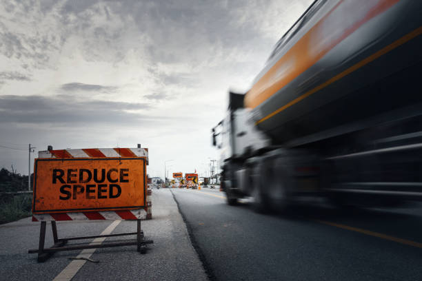 reduce speed road sign on a countryside road with blurry speed truck. - business speed horizontal commercial land vehicle imagens e fotografias de stock