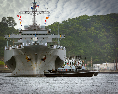 Yokosuka, Kanagawa / Japan - June 24, 2020:  US Navy tugs guide the USS Blue Ridge back to her homeport dock.