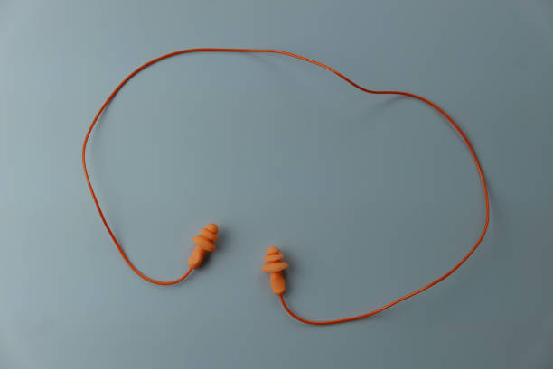 istock Yellow hearing safety protection earplug isolated on a grey background. 1296252730
