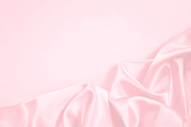 istock Pink silk satin background. Wedding, anniversary, valentine. Beautiful pink abstract background. Soft wavy folds on the fabric. 1296255722