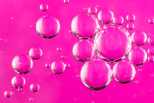 istock oil drops on water on a pink background 1296255846