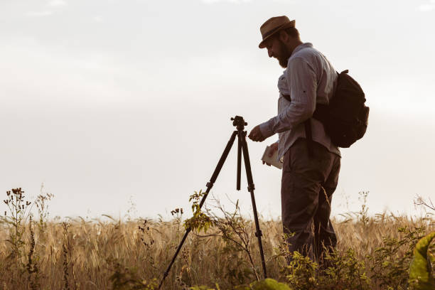 istock a surveyor with a beard set up a tripod on the field 1296259099