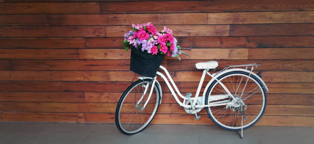 bicicletta con cesto di fiori in colori pastello isolati con legno - hanging flower basket isolated foto e immagini stock