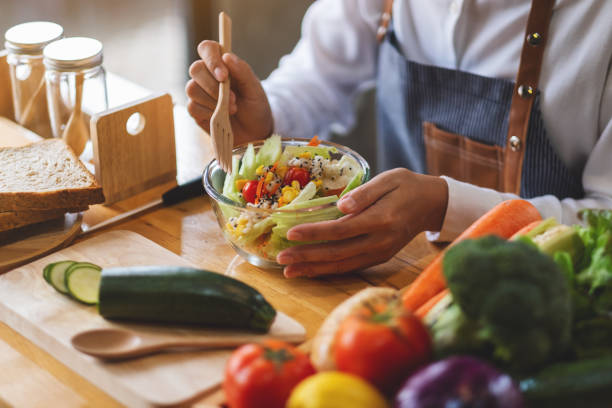 istock a female chef cooking fresh mixed vegetables salad in kitchen 1296262923