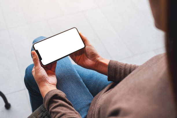 istock a woman holding mobile phone with blank white desktop screen 1296263839