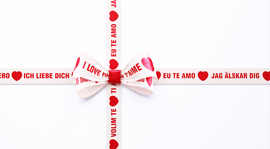 I Love You - Ich Liebe Dich Te Amo Volim Te Jag Alskar Dig - written in different languages on red and white ribbon over white background. Horizontal composition with clipping path and copy space. Valentine's Day concept.