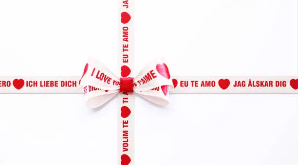 I Love You - Ich Liebe Dich Te Amo Volim Te Jag Alskar Dig - written in different languages on red and white ribbon over white background. Horizontal composition with clipping path and copy space. Valentine's Day concept.