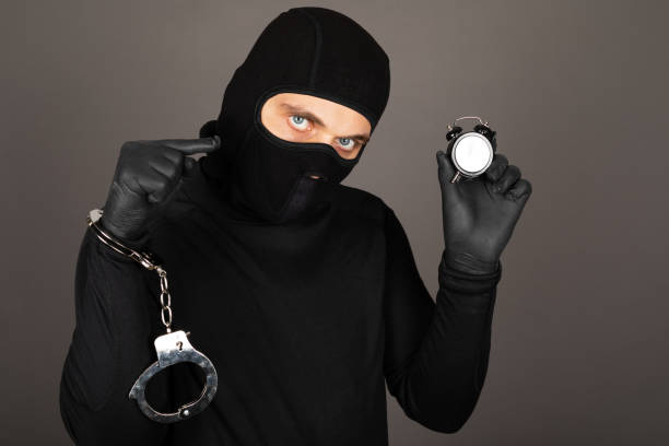 istock Man with black mask with handcuffs 1296265493