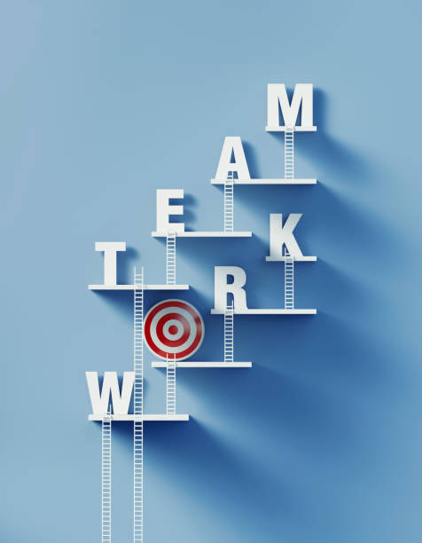 istock White Ladders Leans over A Bull's Eye Target and Writes Teamwork on Blue Wall 1296267325