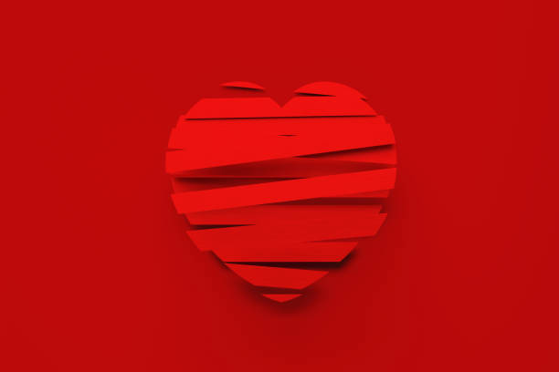 Red ribbons forming heart shape over red background. Horizontal composition with copy space. Valentine's Day and love concept. Copy space available.