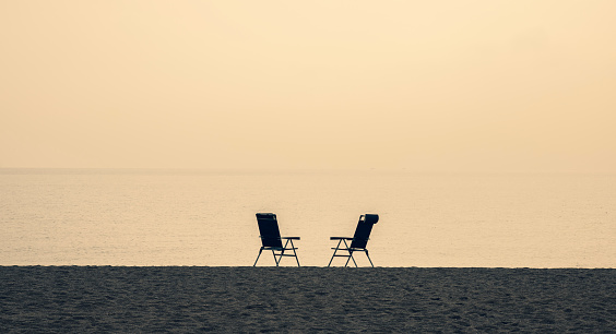 two empty chairs on the beach