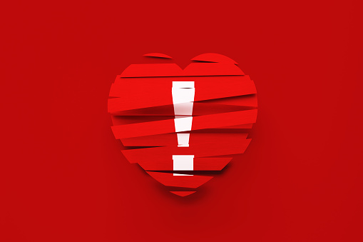 Exclamation Point written red ribbons forming heart shape over red background. Horizontal composition with copy space. Valentine's Day concept. Copy space available