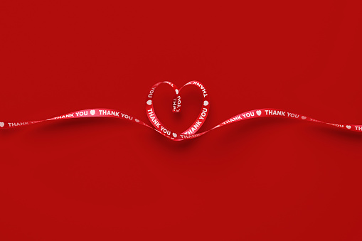 Red ribbon in heart shape isolated on white background. Valentines day Concept