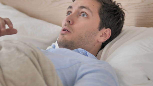 istock Nightmare, Young Man Waking Up in Fear 1296271978