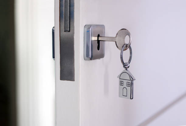 istock Home key with metal house keychain in keyhole 1296273922